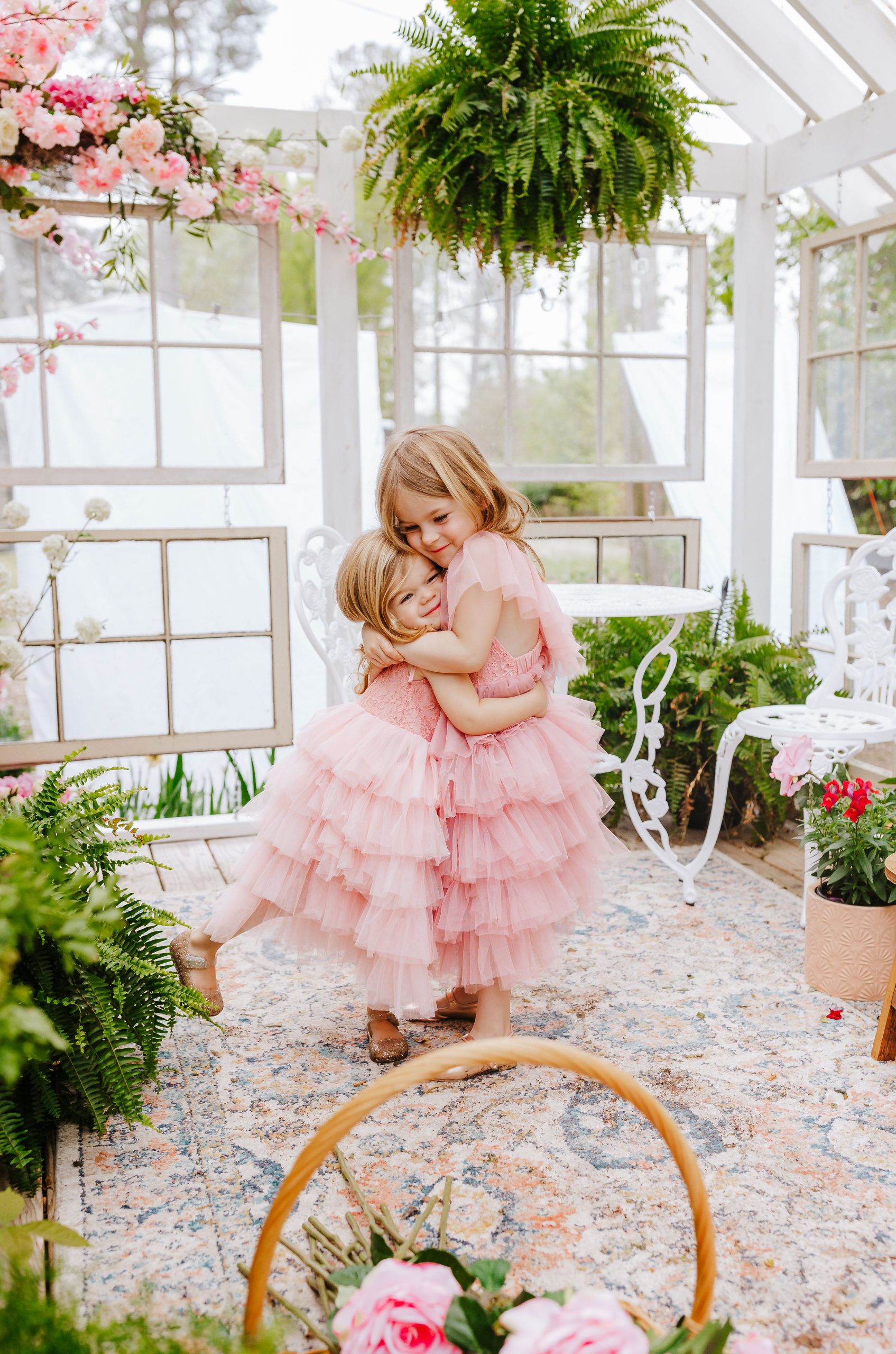 Mother's day photography Nicki Odom's two daughters hugging with pink maxi dresses on for toddlers